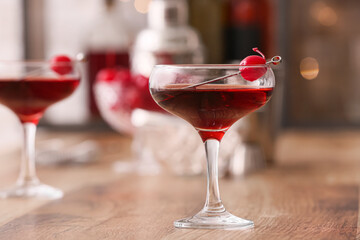 Glass of tasty Manhattan cocktail on wooden table, closeup