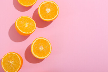 Fresh cut oranges on pink background
