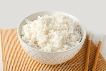 Bowl with tasty boiled rice on light background, closeup