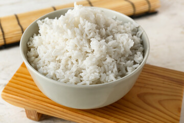 Bowl with tasty boiled rice on light background, closeup