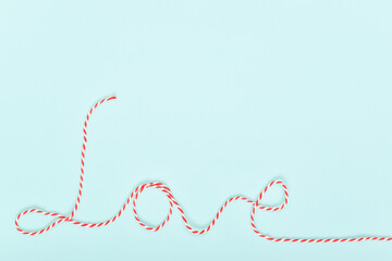 Inscription about love inscription in red and white threads about love on a blue background....