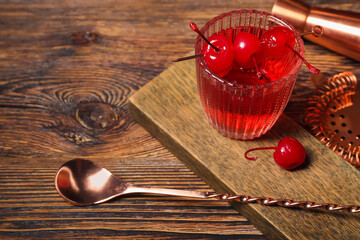 Glass of tasty Manhattan cocktail on wooden background