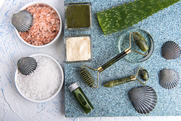 Fototapeta na wymiar Cosmetic procedures for skin care. Jade roller and aloe vera. Sea salt baths and lotions. View from above.
