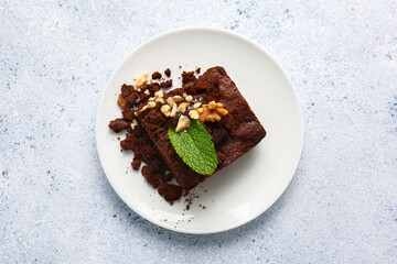 Plate with pieces of tasty chocolate brownie on white background