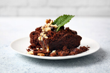 Plate with pieces of tasty chocolate brownie on table