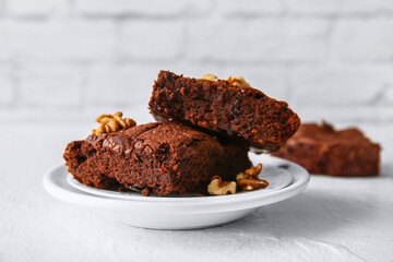Plate with pieces of tasty chocolate brownie on table