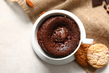 Cup with tasty chocolate brownie on light background