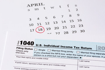 Income tax return form and calendar with filing deadline date. April 18 tax due date, financial information