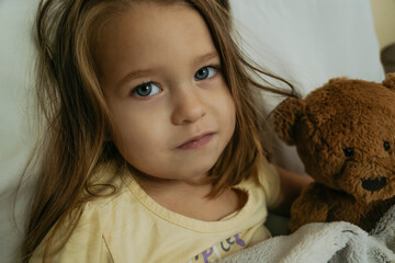 Portrait of sad sick little girl looking to the camera. 