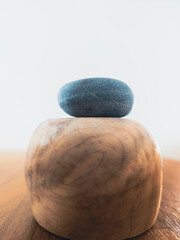 Abstract background image of a blue zen rock on the round wooden pedestal on light gray background