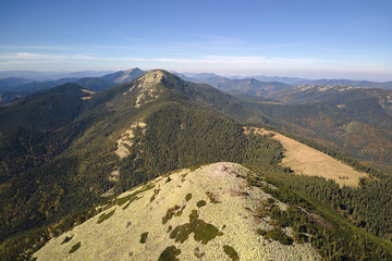 Obraz premium Aerial landscape view of high peaks with dark pine forest trees in wild mountains