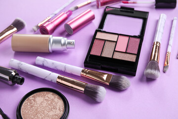 Different makeup products on purple background, closeup