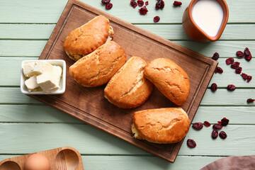Board of tasty sochniki with cottage cheese on green wooden background