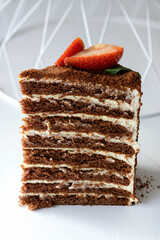 Piece of multi-layered honey cake with fresh berries. Selective focus.