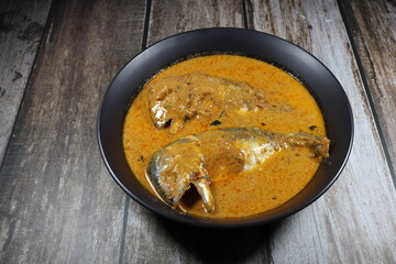 Traditional red curry soup of mackerel fish with coconut milk and curry paste serving in the bowl. Famous spicy seafood menu in Asia restaurant.