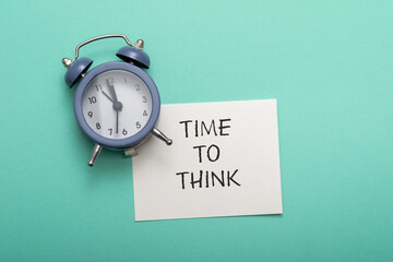 The text Time to Think on a white business card lies next to the alarm clock. business concept think.