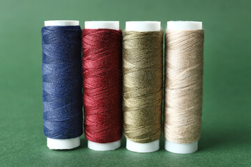 Multicolored sewing thread spools on color background