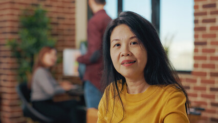 Portrait of business woman using paperwork and laptop to plan marketing presentation. Financial consultant working with statistics to help with company growth and development in office.