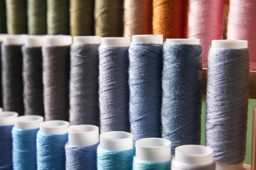 Closeup view of multicolor sewing threads on coils