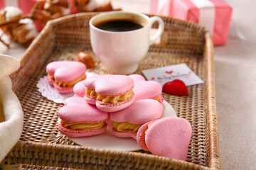 Tray with tasty heart-shaped macaroons on table