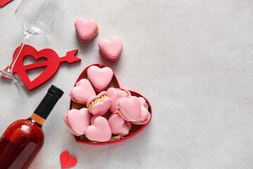 Box with tasty heart-shaped macaroons and decor on light background