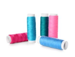 Different sewing thread spools on white background