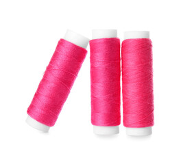 Pink sewing thread spools on white background