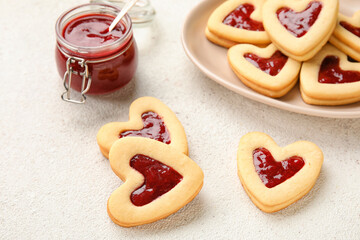 Plate with tasty cookies and jam for Valentine's Day celebration on light background, closeup
