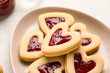 Plate with tasty cookies for Valentine's Day celebration on light background, closeup