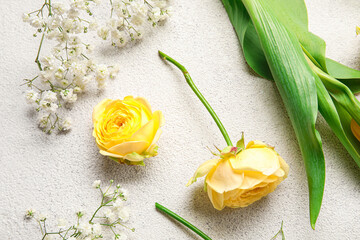 Different beautiful flowers and leaves on light background