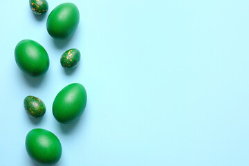 Green painted Easter eggs on color background