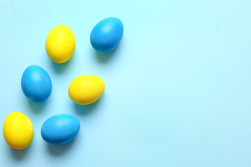 Blue and yellow Easter eggs on color background
