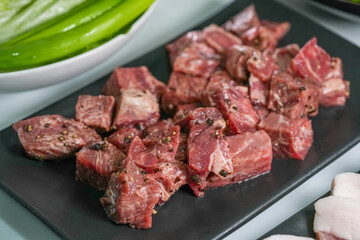Korean beef barbecue a popular Korean dish with small side dishes set, Beef, pork, garlic, minced peppers, fresh vegetables and fresh vegetable salad for korean barbecue