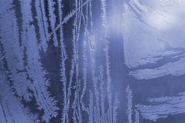 frosty patterns on the window glass closeup. natural textures and backgrounds. ice patterns on...