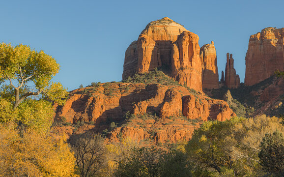 The red rock formations reaching for the sky as the sun warms the stone and highlights the autumn leaves is a typical scenic landscape in the spiritual, beautiful Sedona, Arizona in western USA © Leslie Rogers Ross