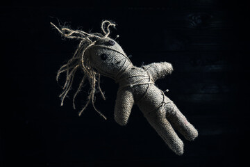 Female voodoo doll with pins on dark background