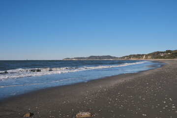 海岸線砂浜と波　青空のコピースペース素材