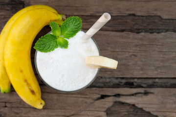 Banana fresh cocktail vanilla smoothies  fruit juice beverage healthy the taste yummy in glass drink episode good morning on wooden background from the top view.