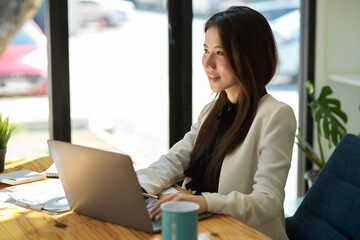 Businesswoman working on her portable laptop in the coffee shop.