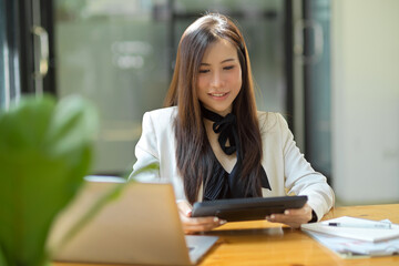 Businesswoman reading the email on her portable tablet.