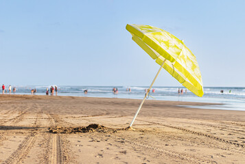 Sombrilla amarilla en medio de la playa.