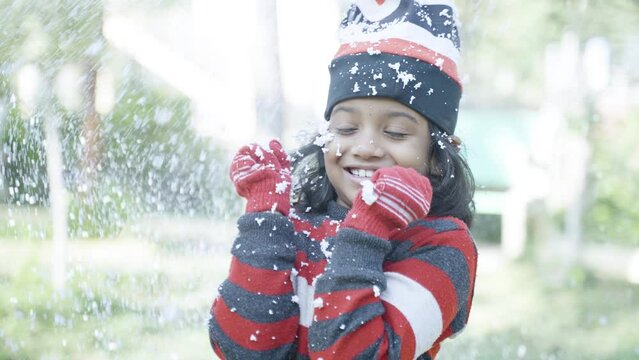 Shivering Indian Girl Kid Standing On Winter Snowfall - Concept Of Fun, Joyful And Freezing Environment