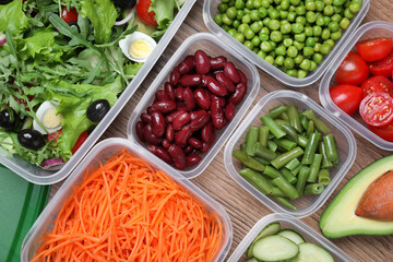 Set of plastic containers with fresh food on wooden  table, flat lay
