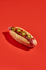 American hot dog with jalopeno on red background minimal style. Fast food on colour background with...