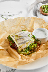 White fish fillet with broccoli in rustic style. Healthy eating: cooked fish fillet with vegetables garnish. Diet food with whitefish and broccoli. Steam vegetables with roasted zander fillet.