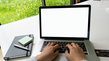 Hands pressing laptop keyboard with white screen and credit card and tiger skin side by side working concept.