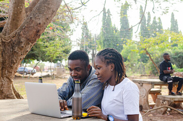 Young black beautiful Male and Female college student focus using laptop on campus