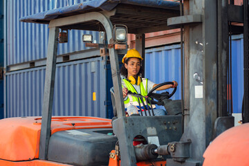 Female foreman is driving forklift at shipping container yard. shipping in docks. © Thanumporn