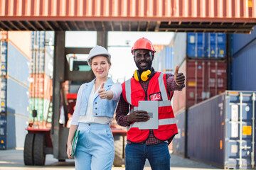 Businesswoman and engnineer showing thumbs up with laptop working at warehouse container cargo ship import export industry.