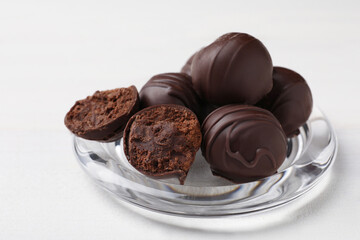 Many delicious chocolate truffles on white wooden table, closeup